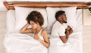 Couple lying on opposite sides of the bed unable to agree on mattress comfort — Texan Mattress Magnolia couples guide