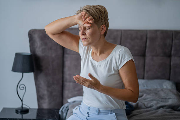 Woman waking up exhausted and overheated in her bedroom — cooling mattress guide from Texan Mattress Magnolia