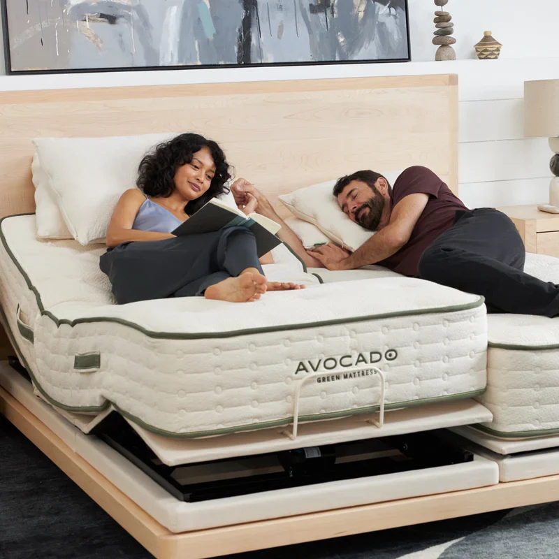 A couple relaxing on their split king avocado mattresses with matching adjustable bases in a bedroom setting.